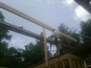 Carpenter setting a ridge beam over a new addition frame — Ice Dam Removal by Roofing Brothers in Williamsfield
