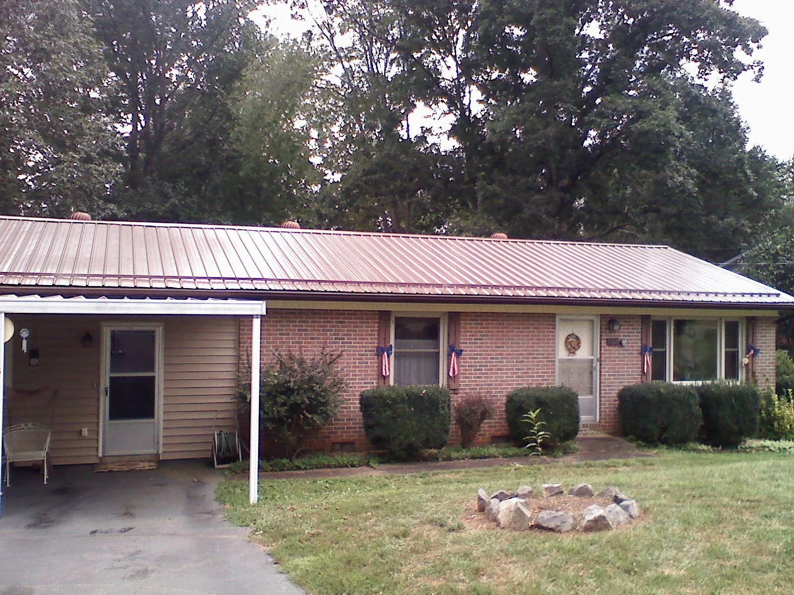 Bronze metal roof and carport on a brick ranch home — Roof Repair work by our crew in Williamsfield