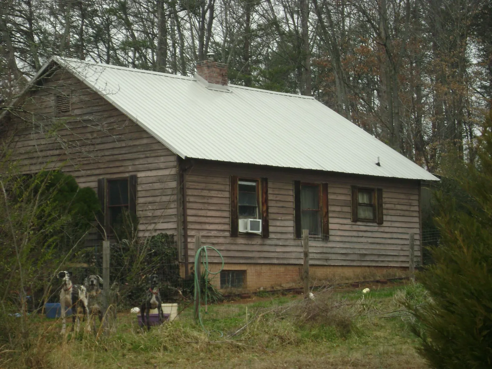White metal roof on an old wood sided farmhouse, from a Metal Roof Installation job in Williamsfield